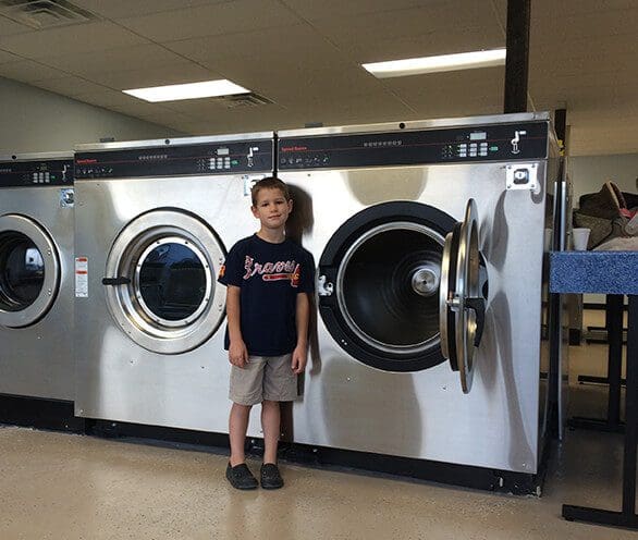 a boy in front of Laundry Machine The Dutchman's Laundry
