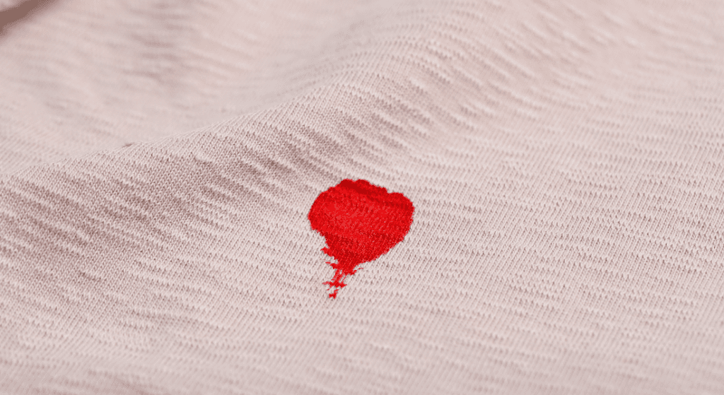 A small red stain on beige fabric. How to Remove Blood Stains From Clothes.