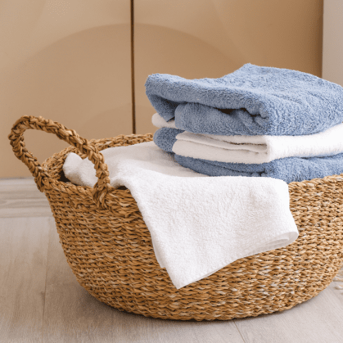 A woven basket on the floor contains folded white and blue towels.