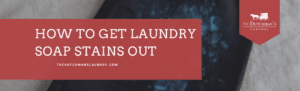 A black garment with white soap stains, overlaid with text: "How to get laundry soap stains out. thedutchmanslaundry.com" and The Dutchman's Laundry logo.