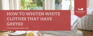A stack of folded white towels, a wicker basket, a bowl with white powder, and a lemon on a table beside a window, with a banner reading "How to Whiten White Clothes That Have Greyed.
