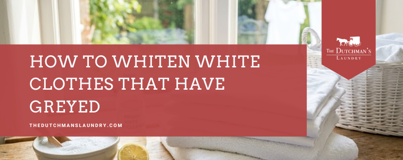A stack of folded white towels, a wicker basket, a bowl with white powder, and a lemon on a table beside a window, with a banner reading "How to Whiten White Clothes That Have Greyed.